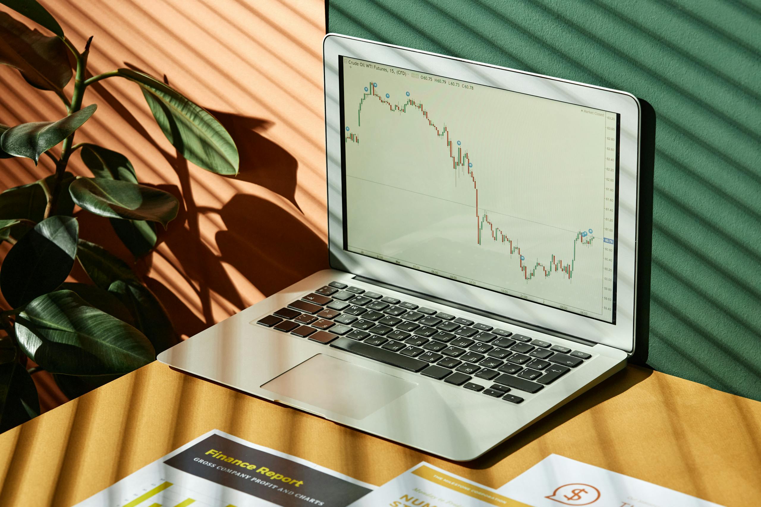 Laptop displaying stock trend lines with warm shadows—representing AI tools for smarter financial decisions in QuickBooks.
